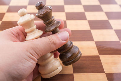 Close-up of hand holding chess piece
