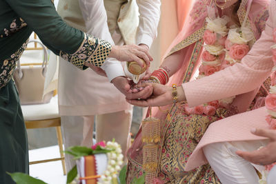 Midsection of couple holding hands