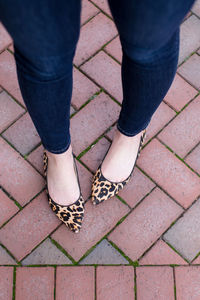 Low section of woman standing on footpath