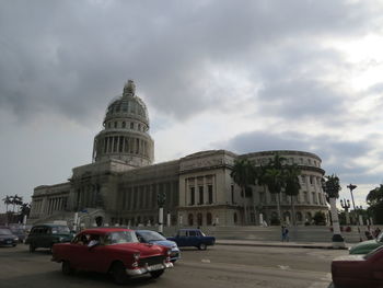 Buildings in city against cloudy sky