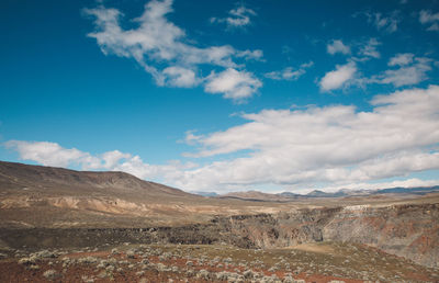 Scenic view of mountains against blue sky