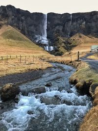 Scenic view of waterfall against sky
