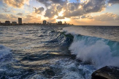 Panoramic view of sea against cloudy sky during sunset