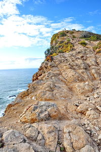 Rock formations by sea against sky