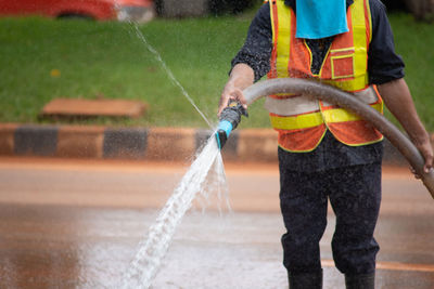 Full length of man holding water splashing