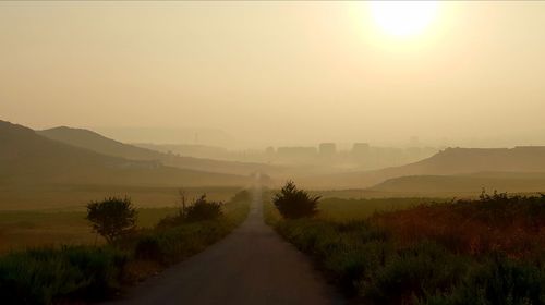 Road amidst landscape against sky during sunset