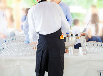Rear view of people standing on table