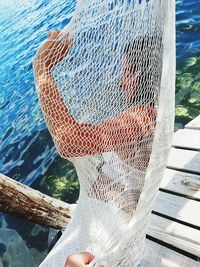 Close-up of human hand by swimming pool