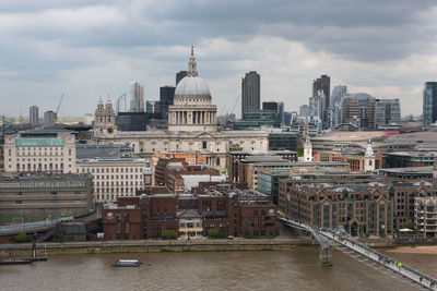 Buildings in city against cloudy sky