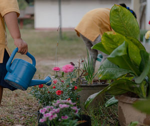 Girl watering potted plants in yard