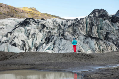 Tourist admiring the solheimajokull glacier, melting as a result of climate change, iceland