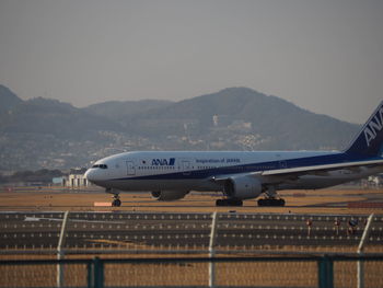 Airplane on runway against sky