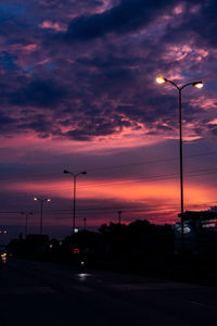 Street lights against sky at sunset