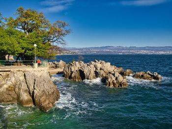 Scenic view of rocks in sea against sky