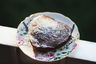 High angle view of heart shaped cake in plate on railing