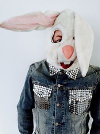 Portrait of man wearing rabbit mask over white background