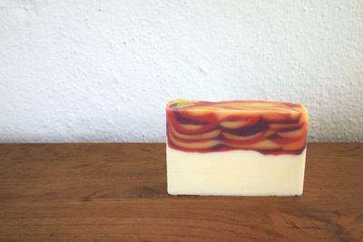 Close-up of cake on table against white wall