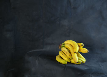 Close-up of yellow fruits on table against wall