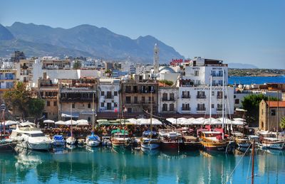 Boats in sea in front of town against clear sky