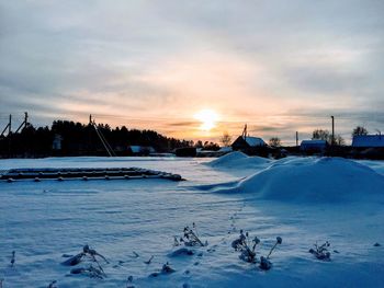 Scenic view of frozen lake against sky during sunset