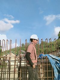 Side view of man standing against sky