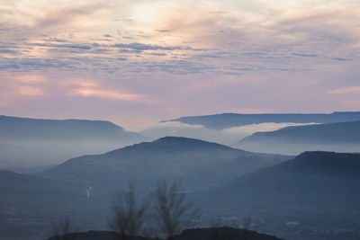 Scenic view of silhouette mountains against sky during sunset