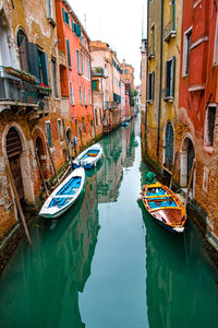 Boats moored in canal amidst buildings in venice city