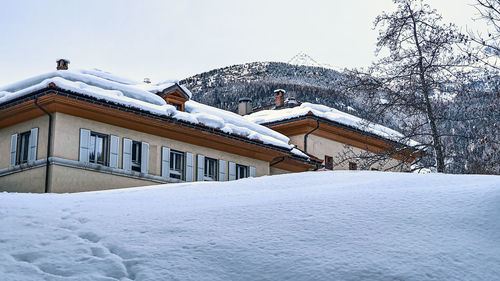 Snow covered houses and buildings against clear sky