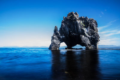 View of rock formation in sea against sky