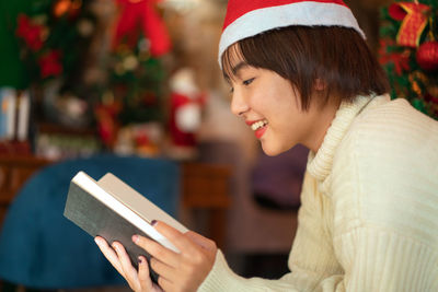 Smiling young woman reading book