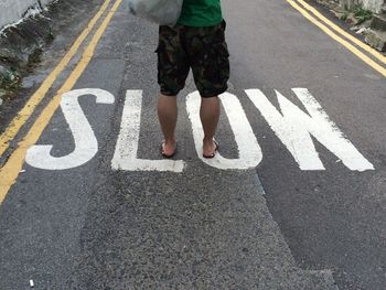 Low section of man standing on road