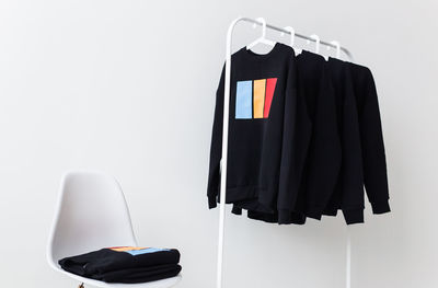 Close-up of clothes hanging on rack against wall at home