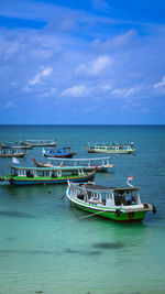 Boats moored in sea against sky