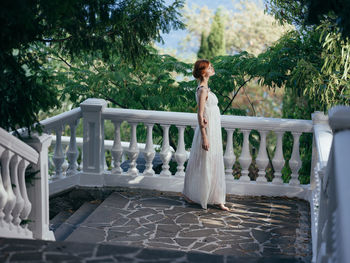 Woman standing by railing