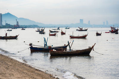 Boats moored in sea against sky