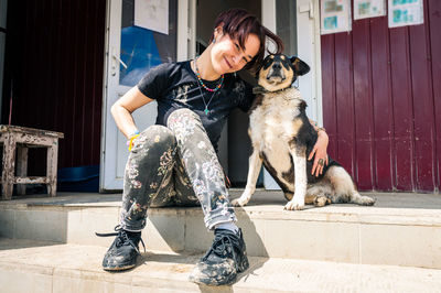 Low angle view of man with dog sitting on street