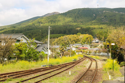 Railroad tracks by mountain against sky