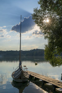 Sailboats moored in lake against sky