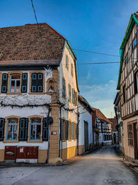 Street amidst buildings in town against sky