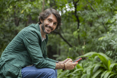 Portrait of young man sitting on field