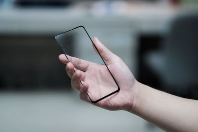 Close-up of hand holding mobile phone