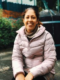 Portrait of smiling young woman sitting outdoors