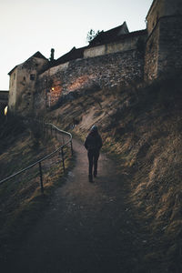 Rear view of woman walking on historical building