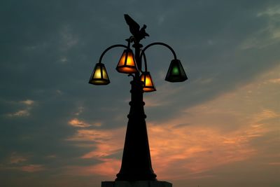 Illuminated light against sky during sunset