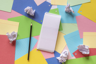 High angle view of colorful papers and pencil on table