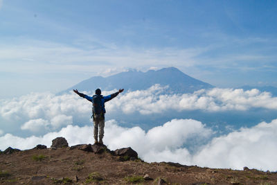 Man standing on mountain against sky