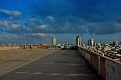 Road by buildings against sky