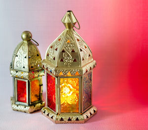 Close-up of illuminated lighting equipment on table against wall