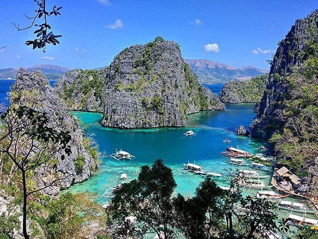 mountain, sea, water, sky, scenics, beauty in nature, blue, rock formation, tranquil scene, mountain range, tranquility, nature, tree, cliff, high angle view, rock - object, coastline, beach, transportation, nautical vessel