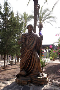 Portrait of buddha statue against trees